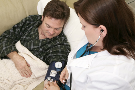 Home Health Nurse Taking Her Patient's Blood Pressure.