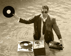 a young dj plays music in the sea - obrazy, fototapety, plakaty