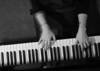 hands of a woman playing the piano