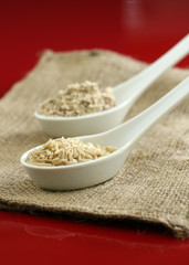 Brown rice and whole wheat flour on a red background