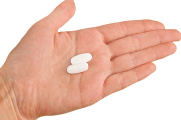 Two white pills on a hand isolated on white background