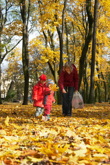 Naklejka premium Happy family in golden autumn city park