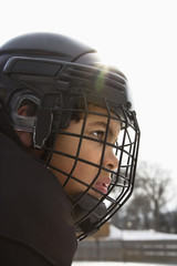 Close up of ice hockey player boy in cage helmet.