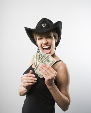 Woman holding twenty dollar bills in hand.