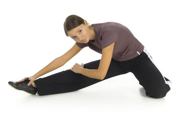 Obraz premium Young woman in tracksuit stretching on the floor