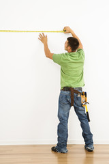 Man measuring wall.