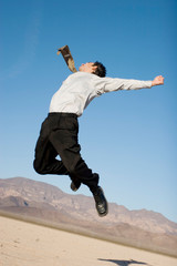Happy businessman jumping in the air