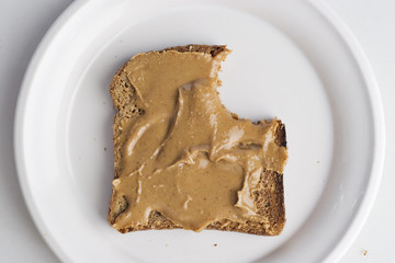 Peanut butter on bread with a bite out of it