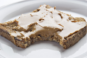 Peanut butter on bread with a bite out of it