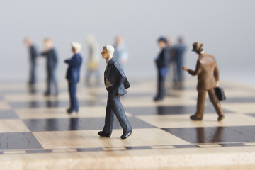 Business figurines placed on chessboard 