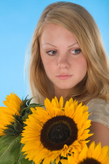 young woman with sunflower on blue background