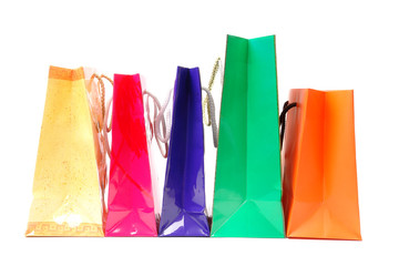 Line of five colorful paper shopping bags over white