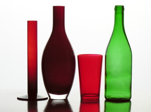 green bottle and red glass and vases