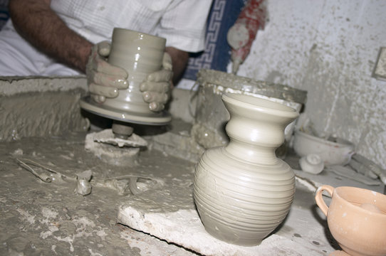 potter making vase on wheel in his workshop