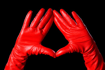 hands in red gloves on the black background showing some signs