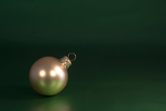 Gold Christmas Ornament On Green Wrapping Paper