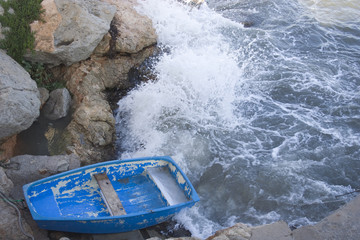 A blue dinghy on the rough sea