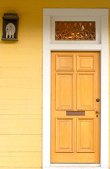 Fototapeta premium A doorway in a bright yellow building with lantern