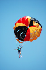 Multi coloured parachute over the blue sky