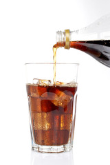 Pouring soda into a glass, on white background. Shallow DOF