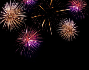 Multiple fireworks exploding with bright trails
