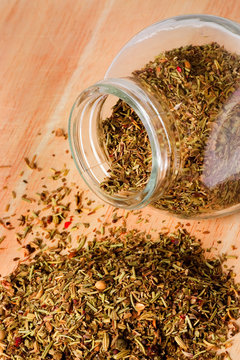 Jar of mixed herbs on a table..