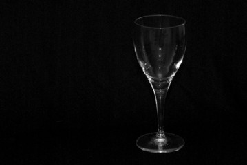 single wine glass shot against a black background