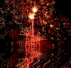 Celebratory firework, reflection in water