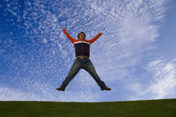 Fototapeta na wymiar young man feeling very happy, jumping at the park