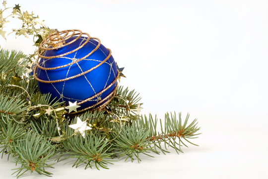 Christmas image of blue ball lying on the piny branch