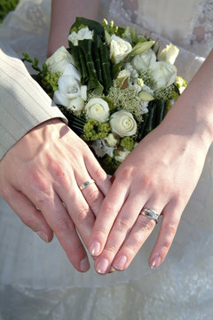 mains de mariés avec alliances et bouquet