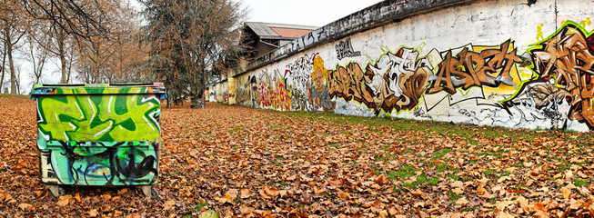 Poubelle et graffitis dans un jardin public en automne