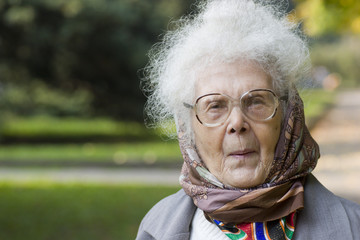 Portrait of Old lady wearing glasses in the park