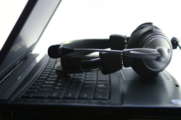 Silver headphones on notebook keyboard.