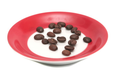 It is a lot of grains of coffee lay on a red plate