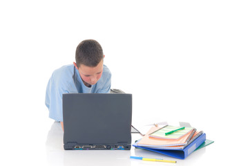 Young boy casual dressed, doing homework on laptop.   