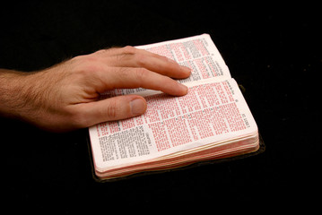 hand of man resting on bible, reading the book of  matthew