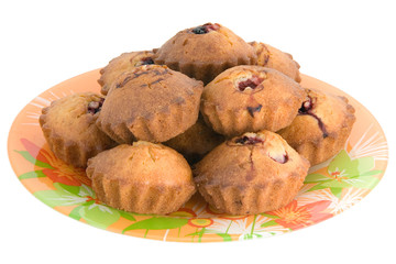 Tasty small baked cakes on orange round plate isolated on white