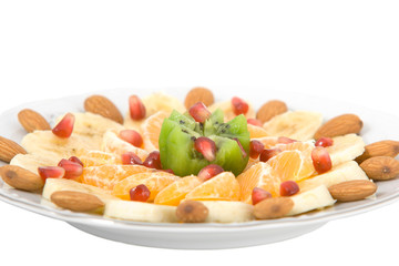 Delicious fruit salad on white round plate isolated on white