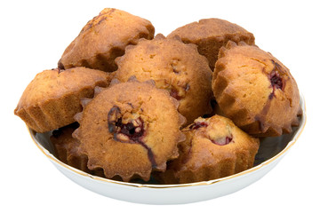 Tasty small baked cakes in white round bowl isolated on white