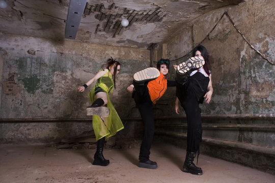 Aggressive girls of goth in a gloomy dirty cellar
