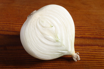 Half an onion on old wooden board