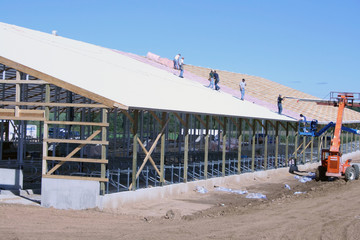 construction workers roof a barn