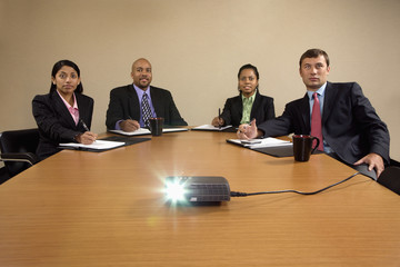 Business team at conference table watching presentation.