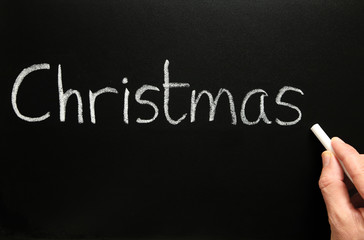 Writing Christmas on a blackboard.