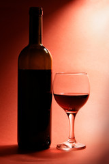 Still-life with bottle of red wine and glass