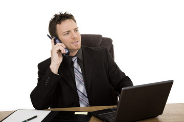 Caucasian businessman setting a desk talking on the phone