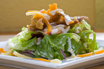 crunchy chicken cesar salad on white platter