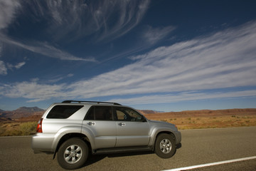 Fototapeta na wymiar Silver SUV driving in Utah.