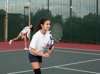 Two girls playing tennis